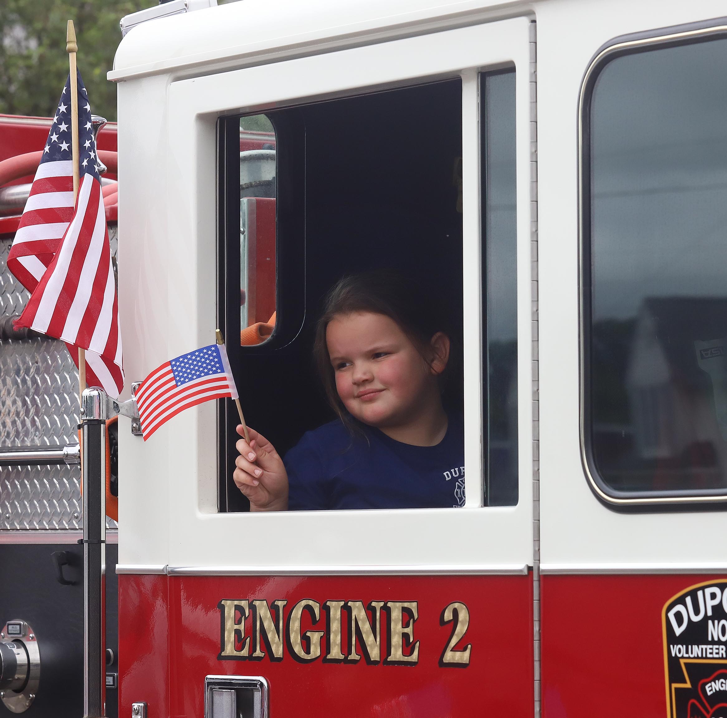 Karsyn Szumski waves an American flag from a Dupont Volunteer...