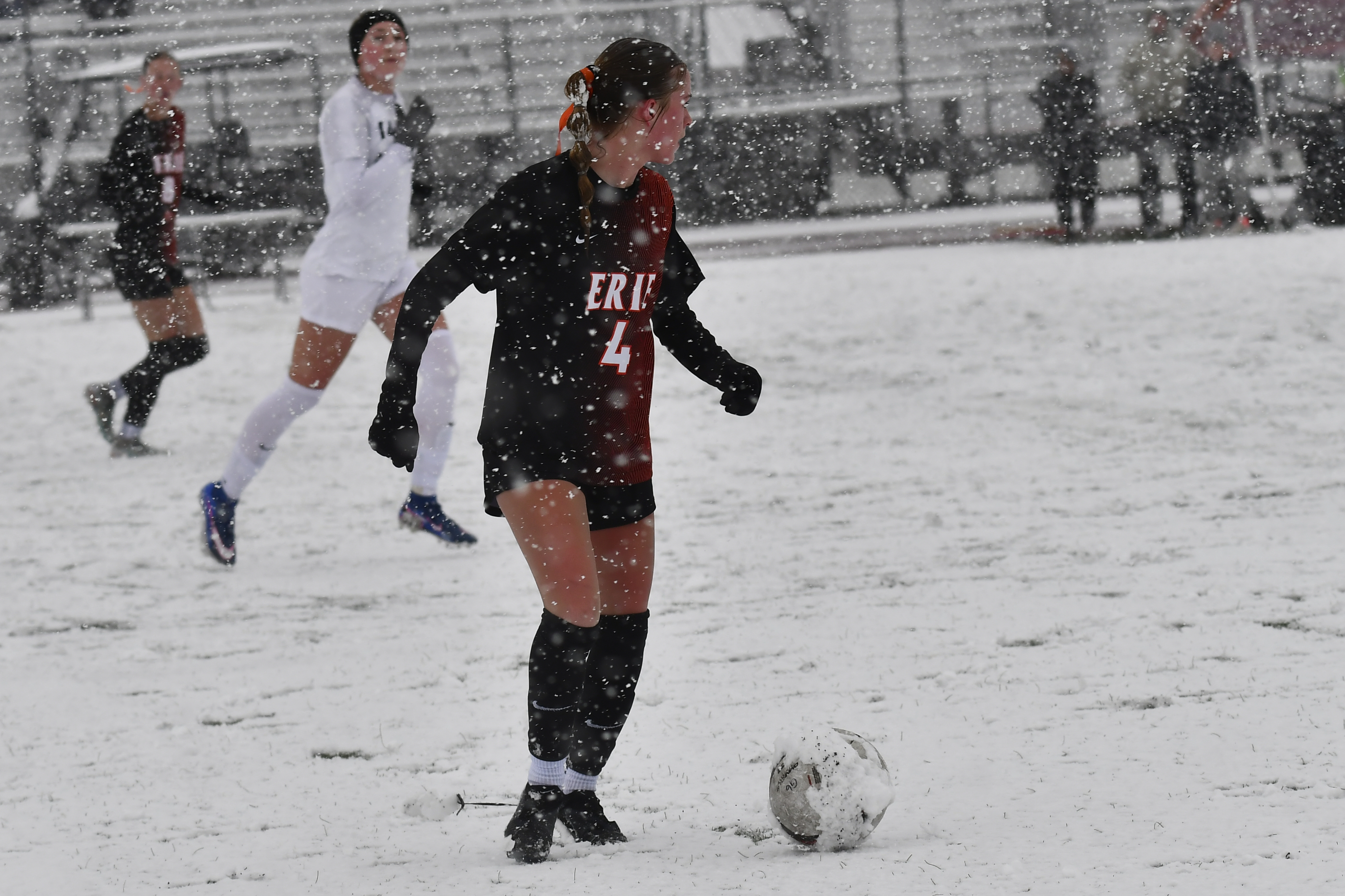 Erieâs Kate Zogorski takes the ball down a snowy field...