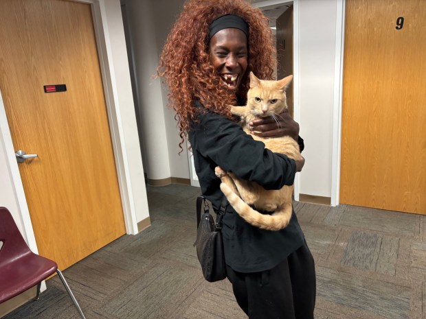 Mkasafari Grace cuddles her kitty, Dots, at the Breaking Bread shelter where they live. (KATHLEEN E. CAREY - DAILY TIMES)