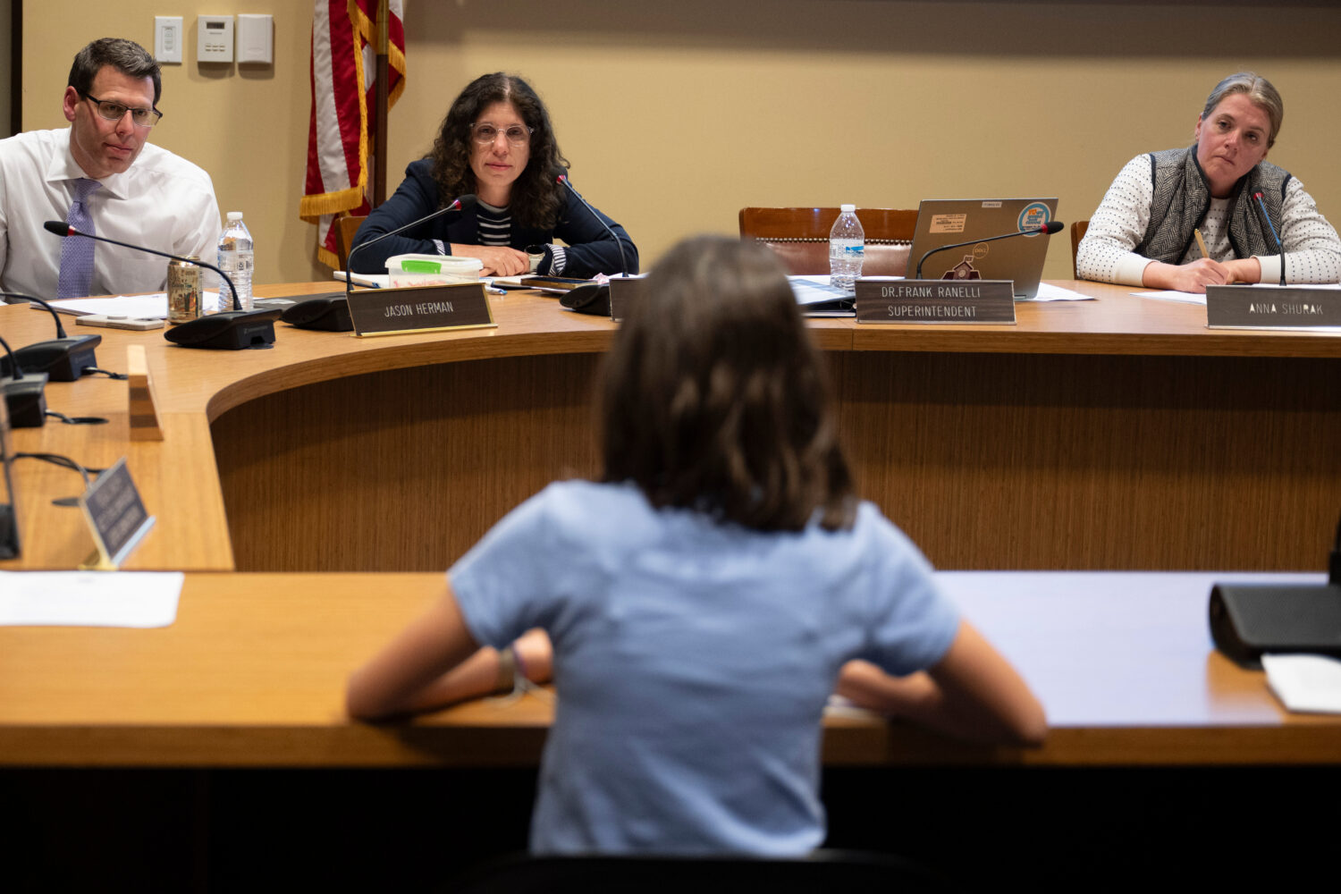 Members of the Lower Merion Board of School Directors speak with a student at a school board meetin...