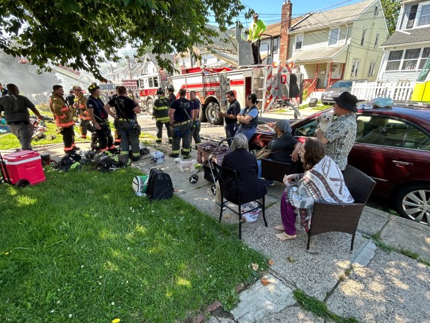 Neighbors and residents watched as crews battled the fire. Some neighbors gave firefighters water to cool off. (PETE BANNAN-DAILY TIMES)