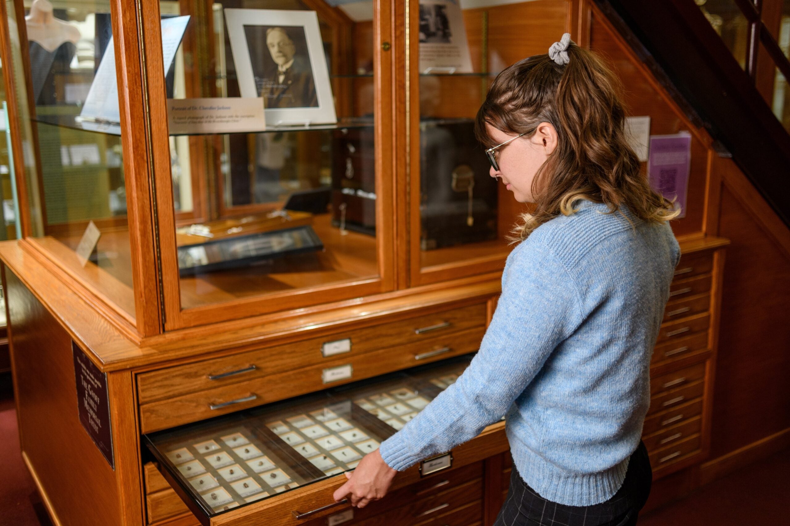 A visitor opens a drawer from the Chevalier Jackson Collection of swallowed objects at the Mütter Museum