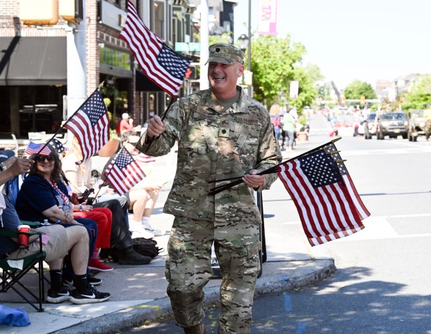Col. Jay Ostrich, director of the Berks County Veterans Affairs, hands out flags during the Armed Forces Day Parade on Penn Avenue in West Reading on Saturday, May 16, 2026.  (BILL UHRICH/READING EAGLE)