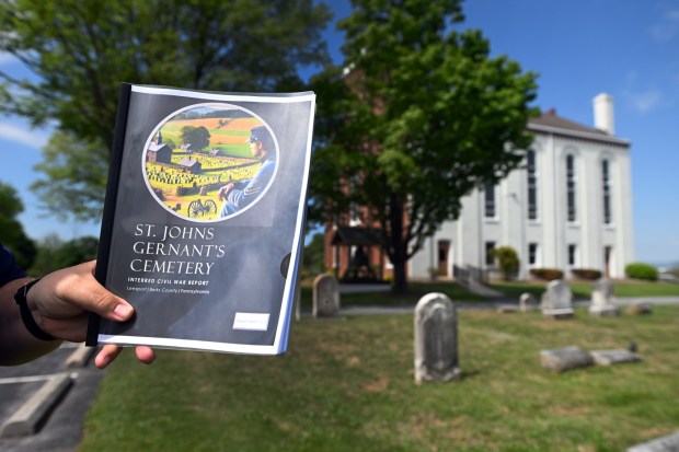 Ben Varner of Centerport holds a copy of the report he compiled on the Civil War veterans buried in the cemetery at St. John's Gernant's Church. (BILL UHRICH/READING EAGLE)