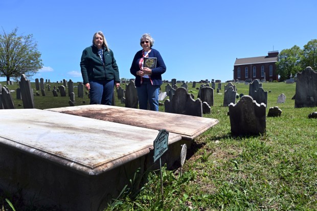 St. John's Gernant's Church historian Mary Jean Kauffman, left, and Pastor Fran Merkel stand at the gravesite of John Gernant, a Revolutionary War veteran who deeded land on which the church and cemetery would be located in Ontelaunee Township. (BILL UHRICH/READING EAGLE)