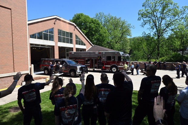 Spectators and firefighters raise their hands in a blessing of the 2025 Ford F250 emergency truck and the 2022 Spartan fire engine by Rev. Bruce Osterhout during the West Reading Fire Co. No. 1 125th anniversary and housing ceremony on Saturday, May 16, 2026, at 223 Playground Dr. (BILL UHRICH/READING EAGLE)