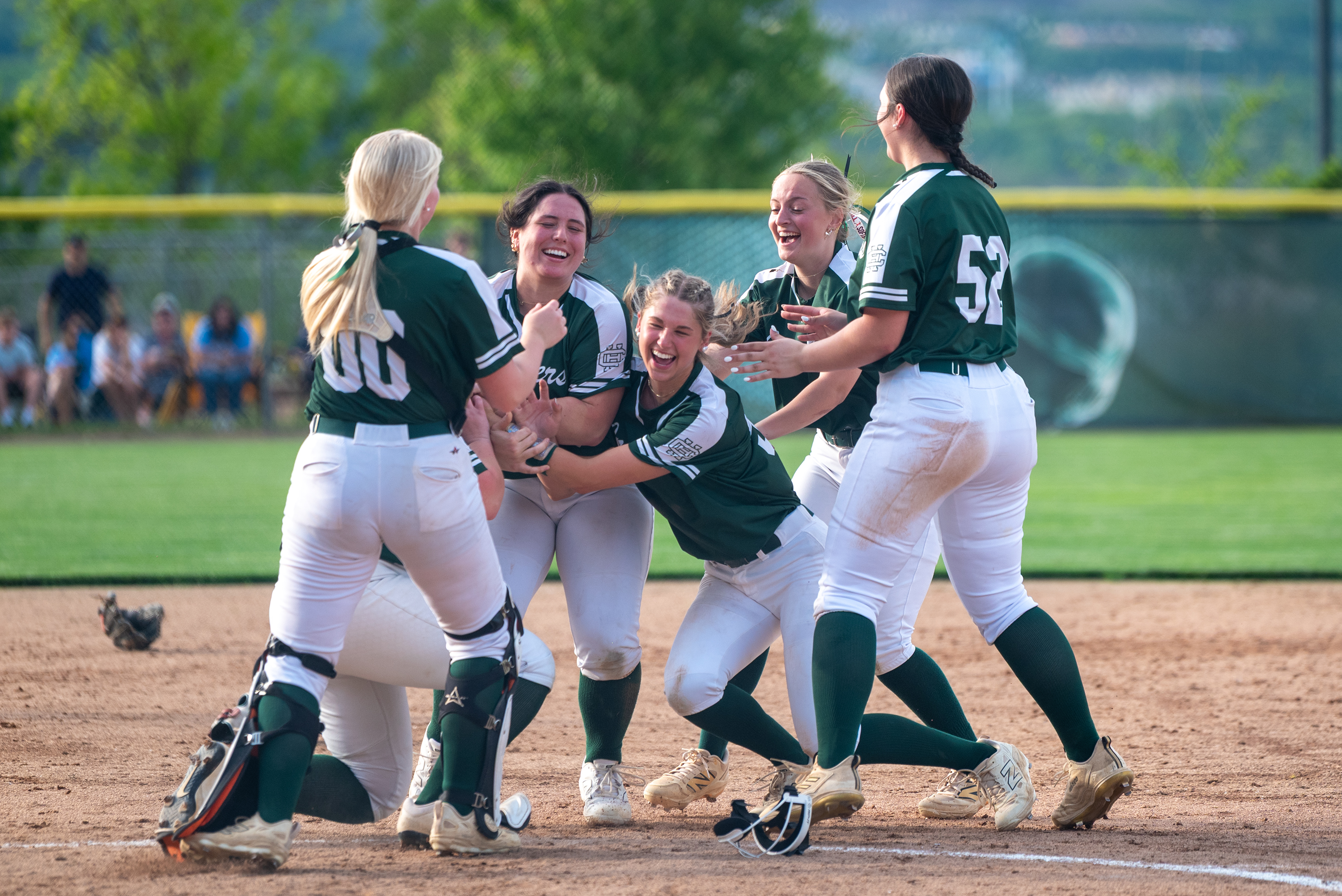 Holy Cross softball players celebrate after winning the District 2...