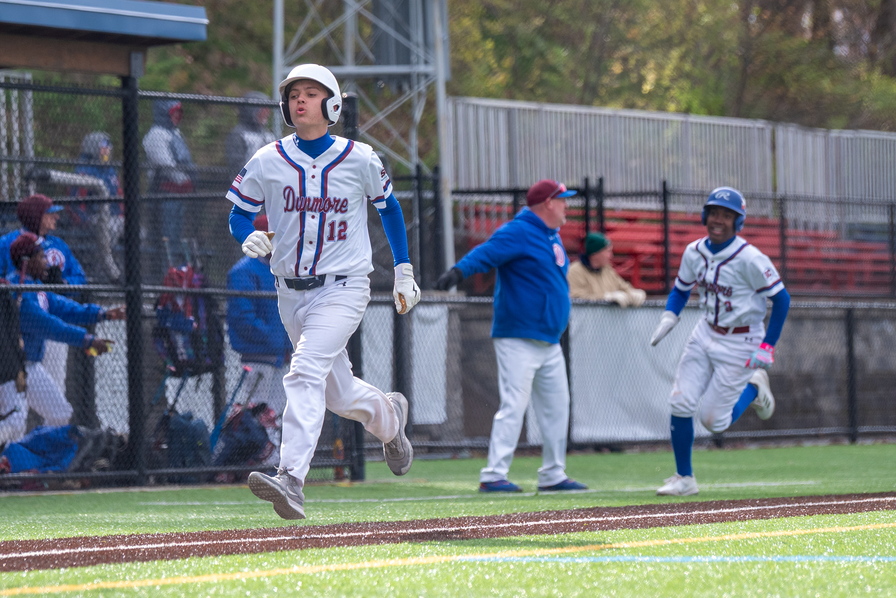 Dunmore’s Diego Arias follows teammate Jimmy Clark toward home to...