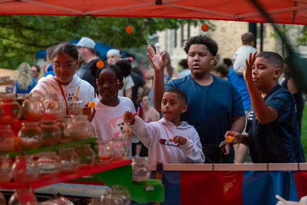 Community members attempt to win a goldfish by tossing balls in to jars during the Scrantastic Firework Spectacular in downtown Scranton on Thursday, July 3, 2025. (REBECCA PARTICKA/STAFF PHOTOGRPAHER)