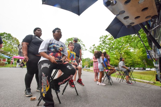 Scranton Cyber Academy students Tyree Russell, 11 and Caleb Daher, both of Scranton, play a video game at the mobile gaming bus, Pixel Reboot, during the school's picnic at Nay Aug Park in Scranton Wednesday, May 27, 2026. (SEAN MCKEAG / STAFF PHOTOGRAPHER)