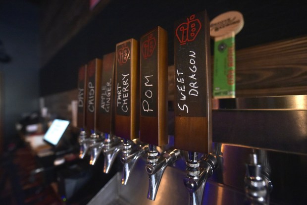 A selection of ciders are available at Electric City Ciderworks on Linden Street in Scranton. Three brothers, Tom, left, Alex, middle, and Mike Borthwick, transformed the downtown property into a new cidery while preserving some of the city's past in the process. (CHAD SEBRING/STAFF PHOTO)