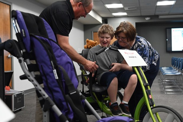 Alicia Acker helps her son Joseph Acker, 9, get adjusted in his new bike during the equipment give away at Northeastern Educational Intermediate Unit in Archbald on Tuesday, May 5, 2026. Acker says it's awesome to receive an adjustable bicycle that can grow with her son. (REBECCA PARTICKA/STAFF PHOTOGRAPHER)