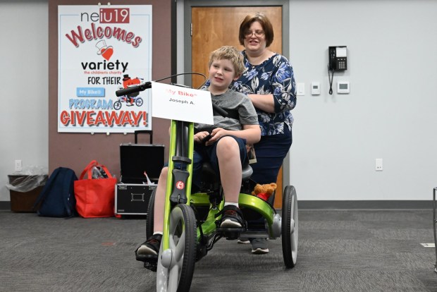 Alicia Acker pushes her son Joseph Acker, 9, as he peddles his new bike during the equipment giveaway at Northeastern Educational Intermediate Unit in Archbald on Tuesday, May 5, 2026. (REBECCA PARTICKA/STAFF PHOTOGRAPHER)