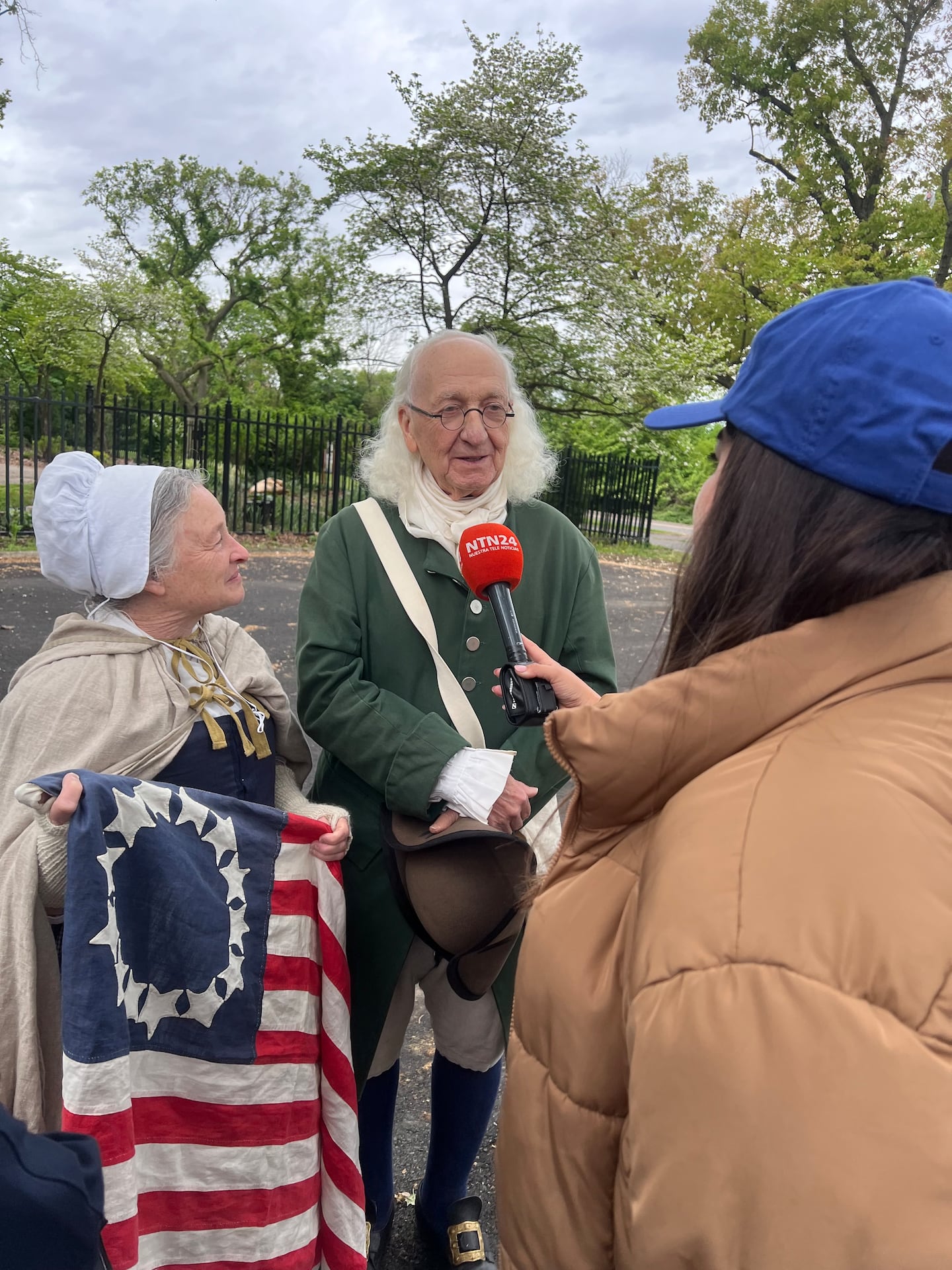 A TV news crew interviewed costumed impersonators of Ben Franklin and Betsy Ross during a tour of the site of this summer's FIFA World Cup fan festival.