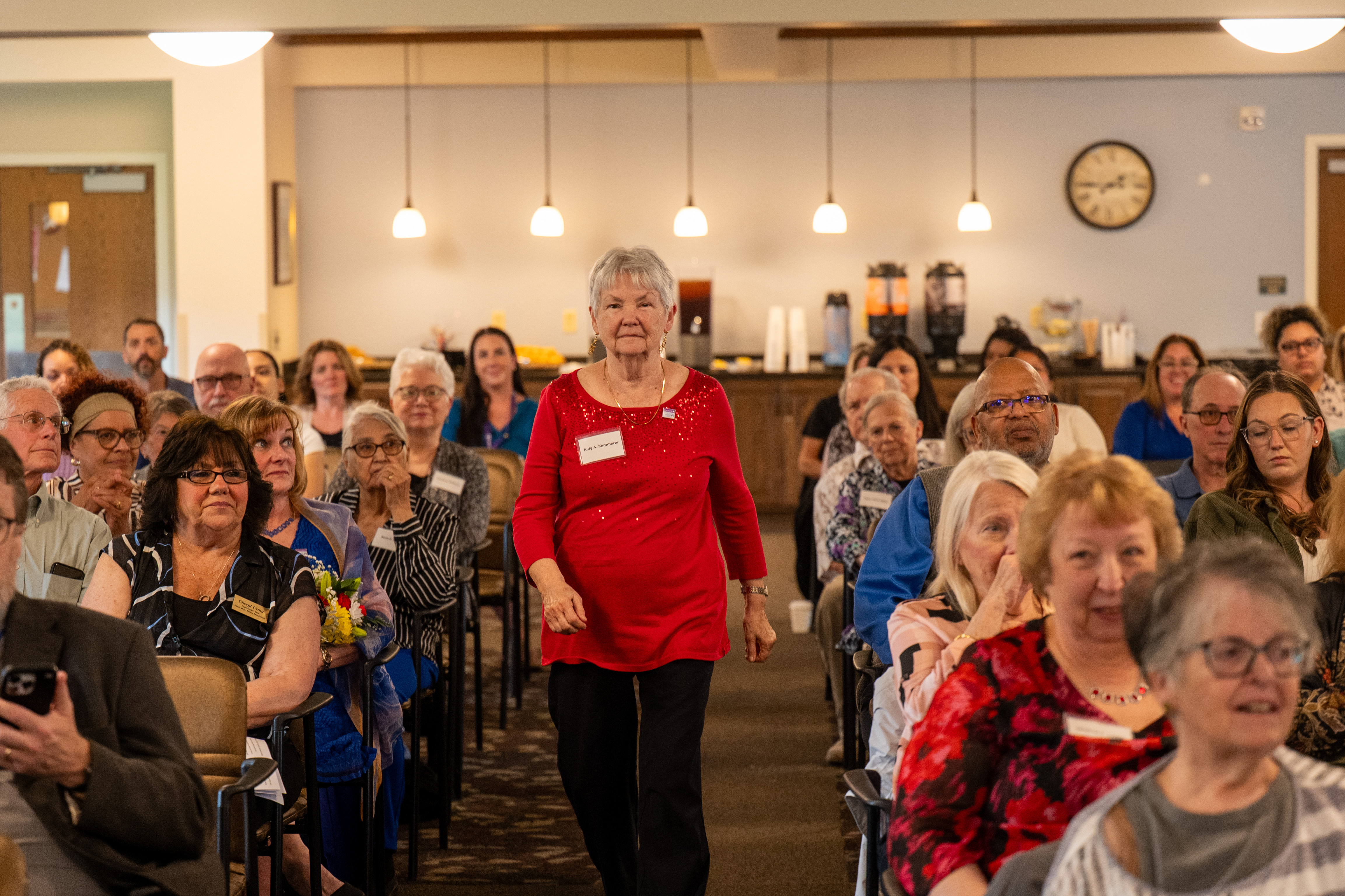 Judy Kemmerer of North Whitehall Township walk down to receive her award during Lehigh County Aging & Adult Services' 26th annual tribute Wednesday, May 13, 2026, at Fellowship Community's Zentz Center in Whitehall Township.Kemmerer is a longtime volunteer for the Parkland Public Library. The annual tribute recognizes older adults who have enhanced their communities through active engagement, volunteerism and service to others. (Jonathan Broady/Special to The Morning Call)