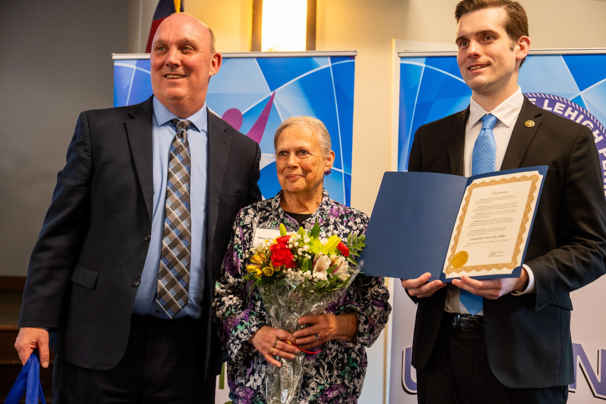 JR Reed of Lehigh County Aging & Adult Services and Lehigh County Executive Josh Siegel present an award to Mary Alice Miller of Allentown during the 26th annual Unsung Heroes tribute Wednesday, May 13, 2026, at Fellowship Community's Zentz Center in Whitehall Township. The annual tribute recognizes older adults who have enhanced their communities through active engagement, volunteerism and service to others. (Jonathan Broady/Special to The Morning Call)