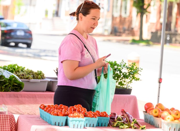 Enjoying the sunshine, Victoria Latharop of Bethlehem stopped to buy farm fresh eggs on her walk Tuesday, May 26, 2026, at Bethlehem Health Bureau's Christmas City Farm Stand partnered with Bleiler's Produce Patch at Payrow Plaza in Bethlehem. The farm stand and weekly community supported agriculture produce pickups continue till October. (April Gamiz/The Morning Call)