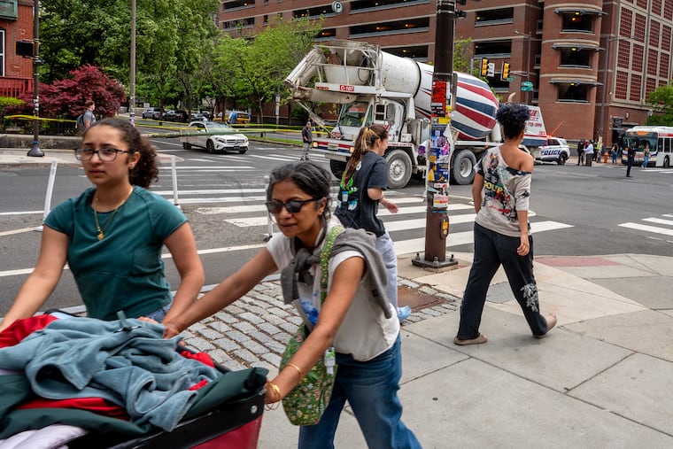 Traffic is jammed in University City Wednesday - in the middle of UPenn move-out day - after a cement truck struck a wire and pulled a utility pole down on a car (rear) stopped at the traffic light.