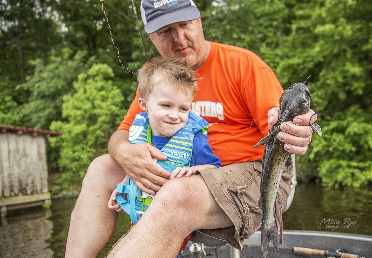 kid fishing with dad. they got one!