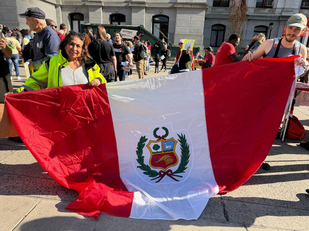Miriam Avila, an immigrant from Peru, holds a Peruvian flag during the May Day rally in Philadelphia