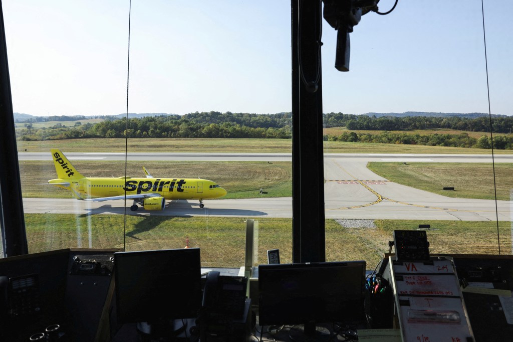 A Spirit Airlines flight on a runway as seen from an airport control tower.