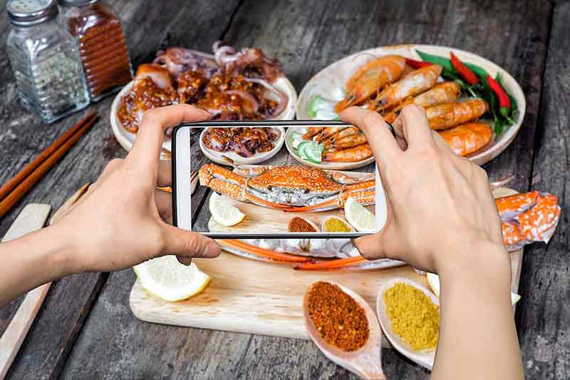 things to do in scranton pennsylvania Girl taking pictures on mobile smart phone a jumbo crab and spices herb.