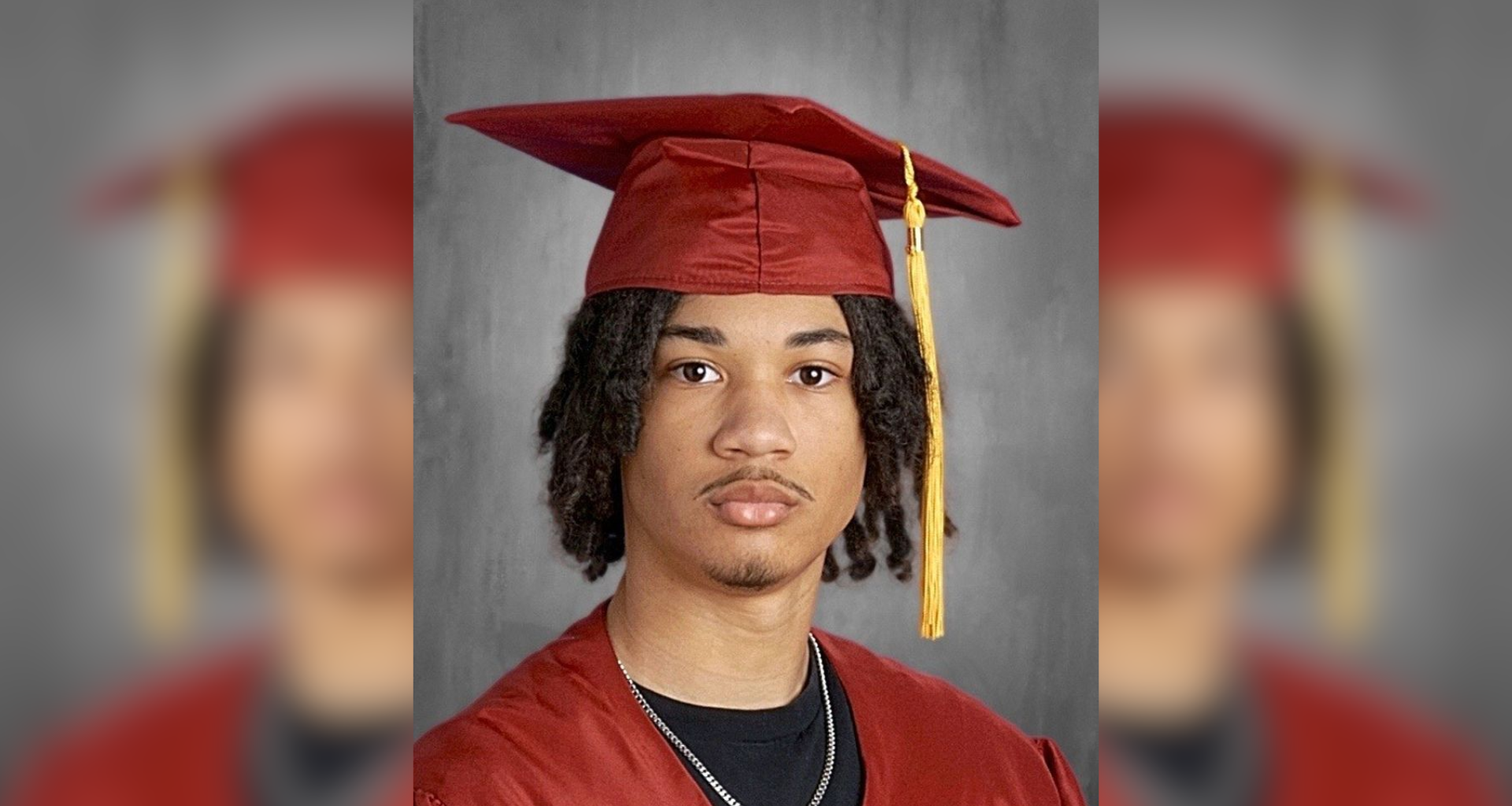 Tymell Millan-Mason poses for his Lincoln Leadership Academy Class of 2026 senior portrait, wearing a red graduation cap and gown with a gold tassel over a black t-shirt and silver chain.