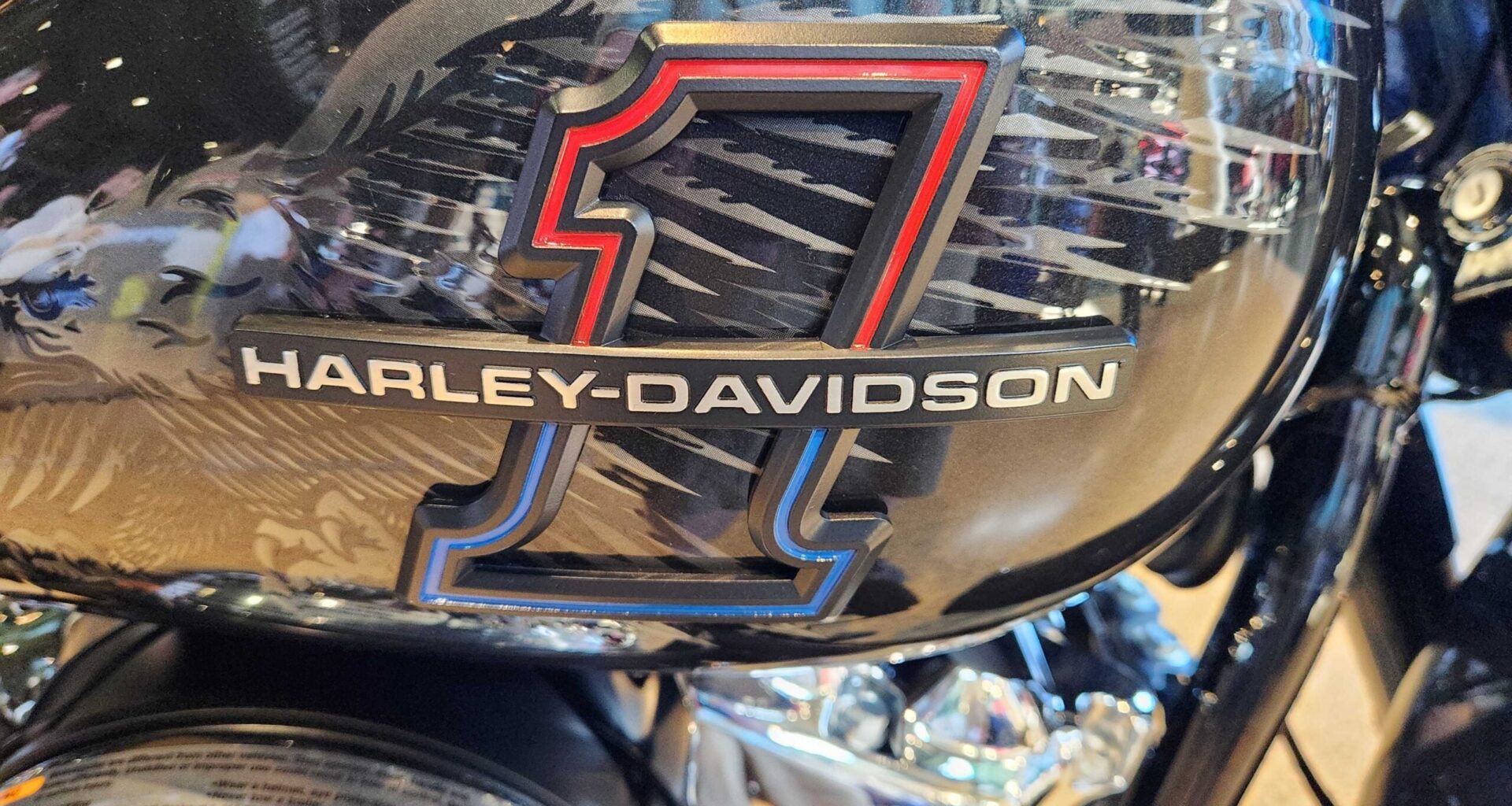 Close-up of a Harley-Davidson motorcycle gas tank featuring a large number 1 graphic and the Harley-Davidson logo.