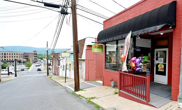 <p>Angy’s Tropical Juice Bar, right, is just steps away from the Tomato Festival lot and a short walk from the Waterfront Warehouse, far left, and the future Market & Main, a seven-story housing and retail building.</p>
<p>Tony Callaio | For Sunday Dispatch</p>