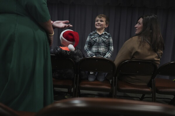 A boy waits for the start of the community putz, a Moravian tradition that retells the story of Christ’s birth with miniature wooden figurines, music and narration, in Bethlehem, Pa., on Sunday, Dec. 1, 2024. (AP Photo/Luis Andres Henao)