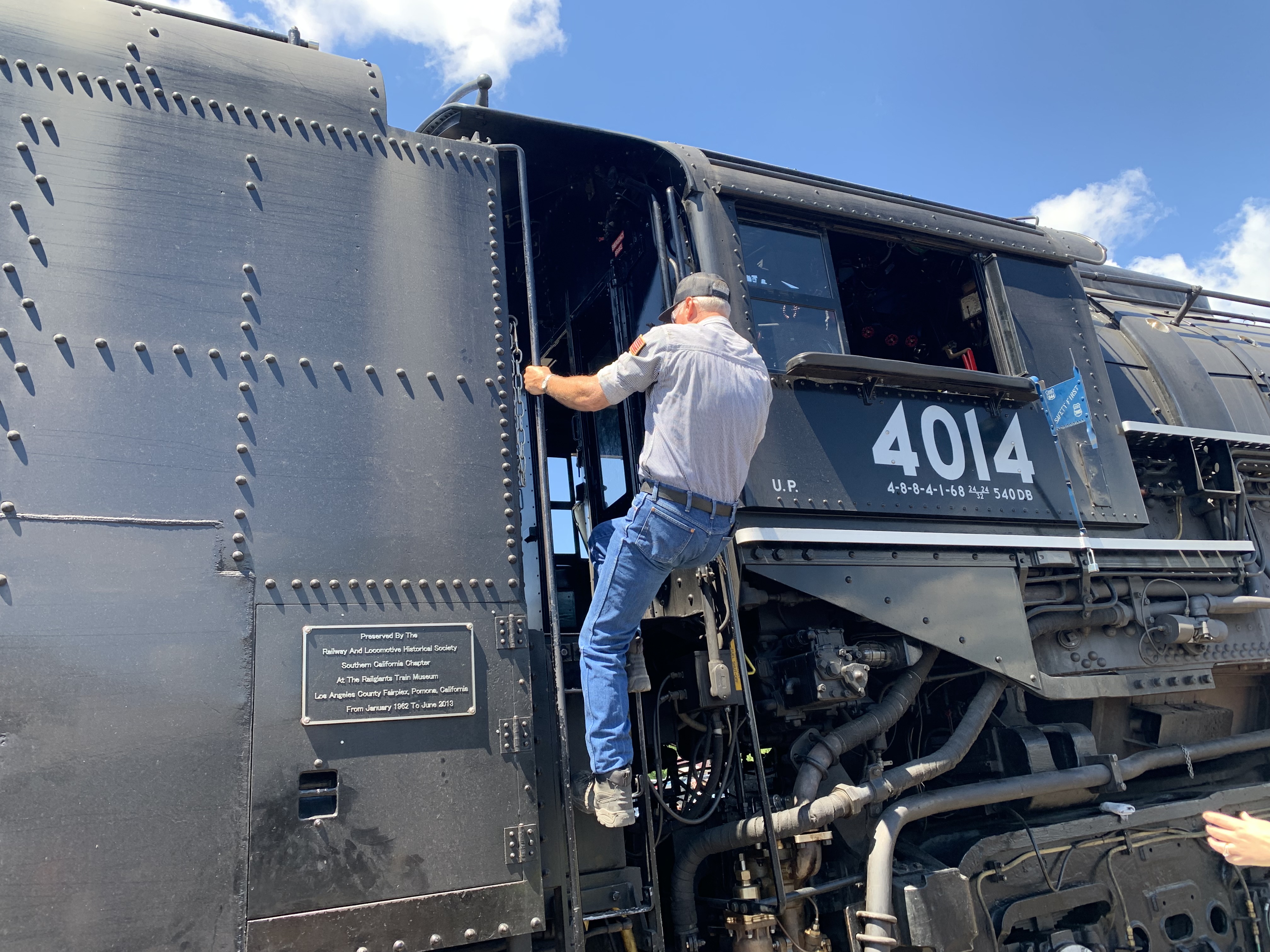 Union Pacific train engineer Ed Dickens climbs a ladder into...