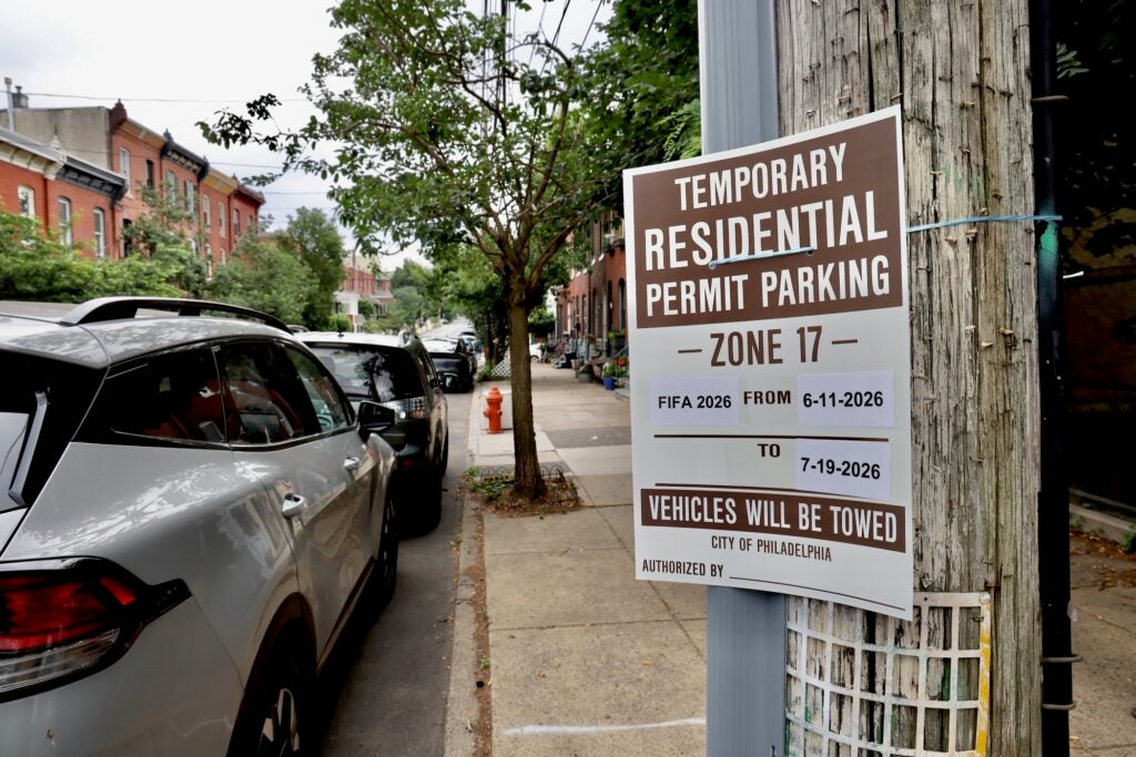 A sign on a lamppost warns drivers that the street is for residential permit parking only.