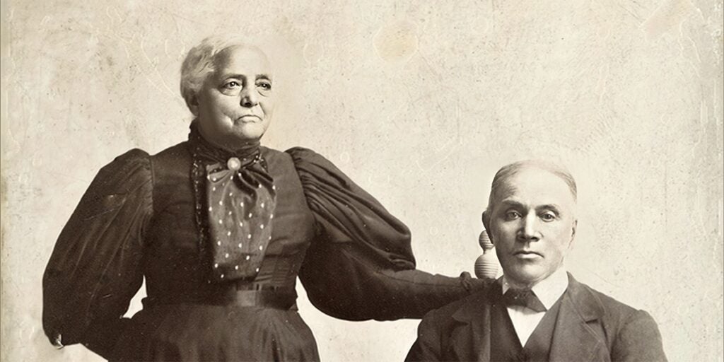 Basil Biggs sitting in a chair, with Mary Jackson Biggs standing next to him.