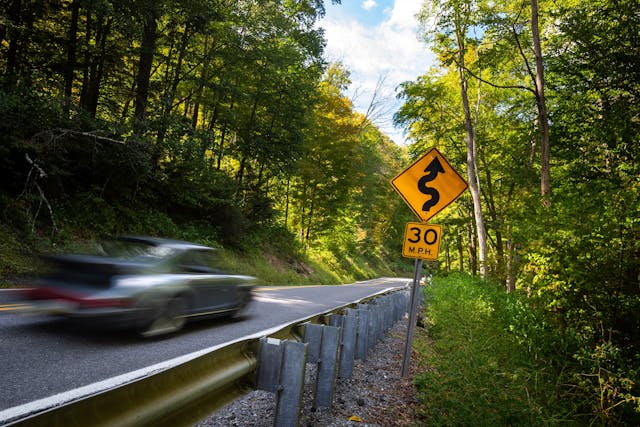 1983 Porsche 911SC blur curving road sign
