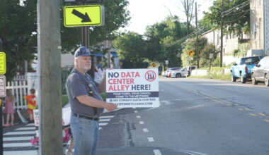 Neighbors line the street during a peaceful demonstration on June 24, 2026, to protest the building of a hyperscale data center in Plymouth Township.