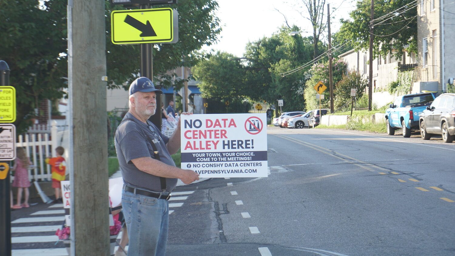 Neighbors line the street during a peaceful demonstration on June 24, 2026, to protest the building of a hyperscale data center in Plymouth Township.