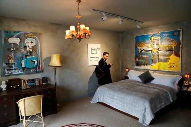A visitor looks at a bed inside street artist Banksy's newly opened Walled Off hotel in the Wes...