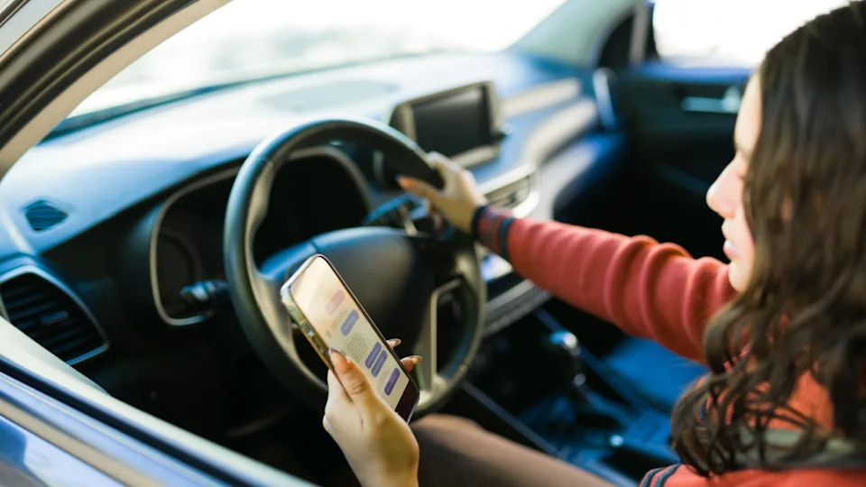 Teenage driver on her phone texting while driving