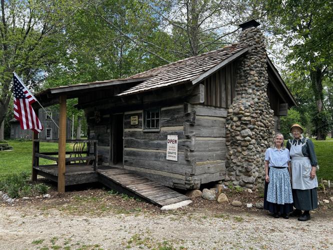 Linda Cooper and Beverly Seese, volunteers, with completed Deer-Crone Cabin at Canal Park.JPG
