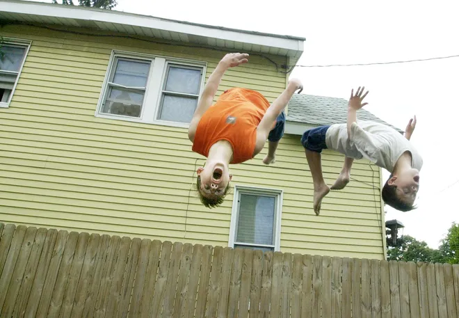Lucas Schmode, 12, and Alex Schmode, 10, flip on a trampoline in their backyard in the 1000 block of Adams Street in Millcreek Township in August 2001.