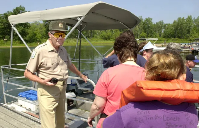 Fred Thompson directs guests aboard the pontoon boat he pilots the lagoons at Presque Isle State Park in August 2001. Check out more lagoons photos: Presque Isle State Park lagoons offer a getaway for fishing and kayaking
