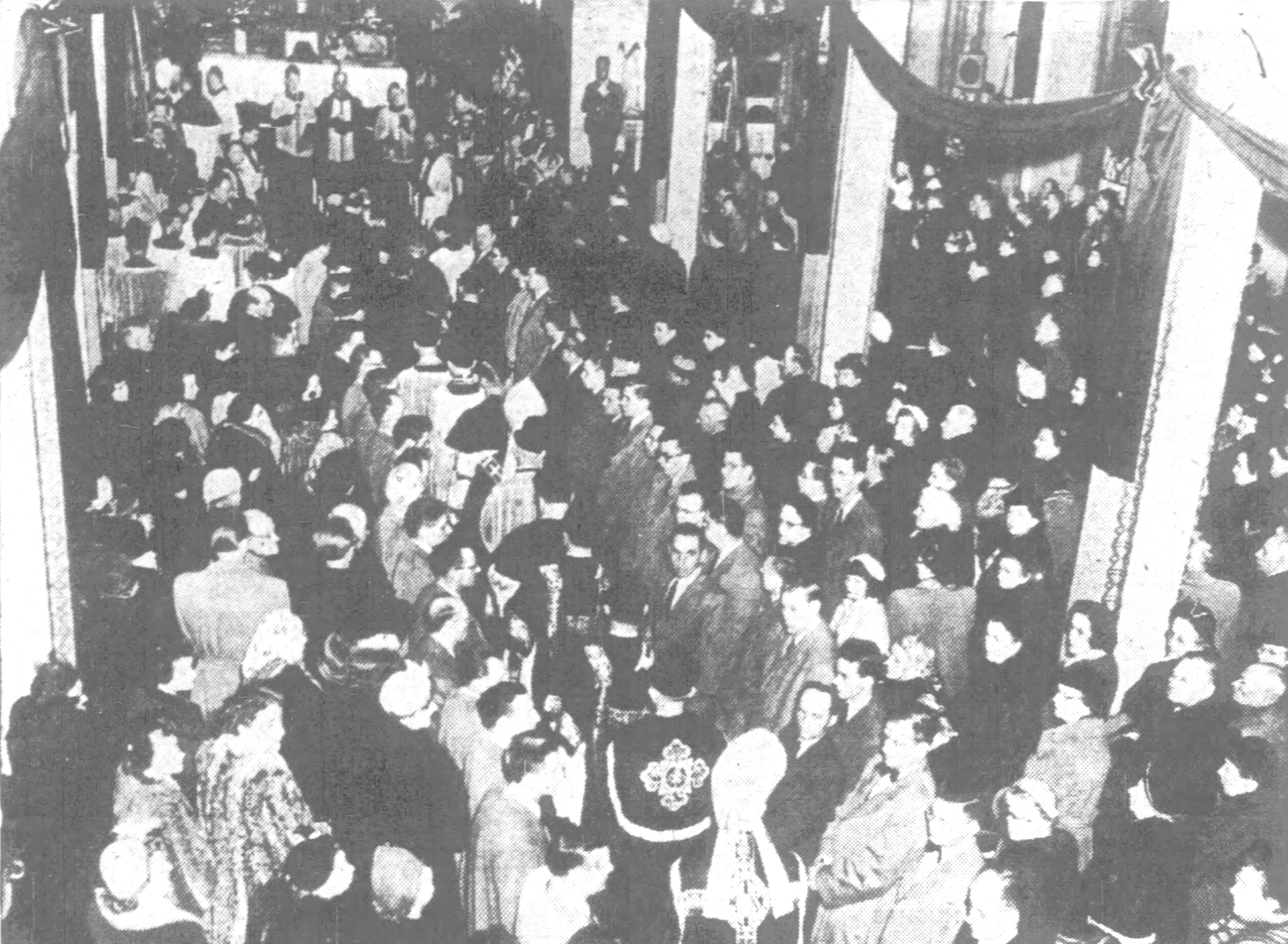A procession of clergy led by officers of the mass,...