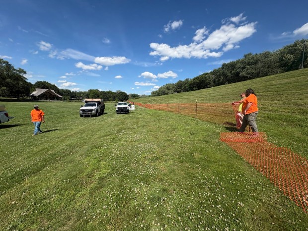 Wilkes-Barre Department of Public Works crews put up fencing along the bottom of the levee in Kirby Park ahead of Saturday's America250PA concert featuring Lady A and En Vogue. (BOB KALINOWSKI / STAFF PHOTO)