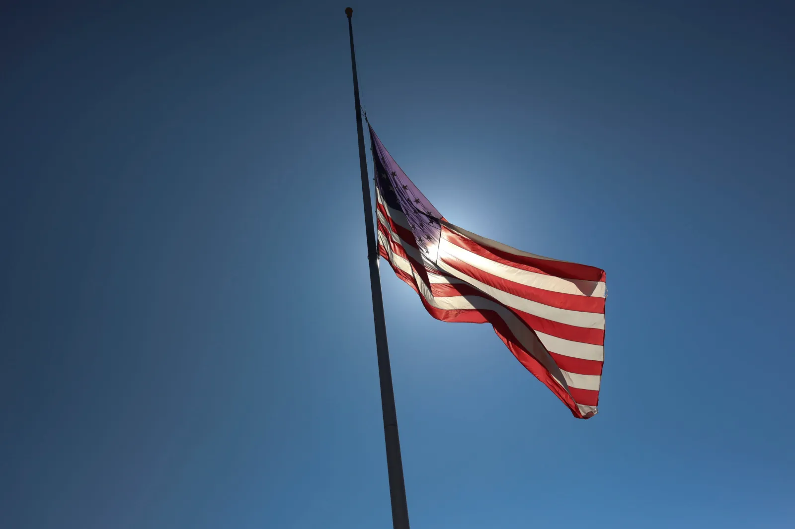 File Image: A flag flies at half staff at Miramar National Cemetery on August 27, 2021, in San Diego, California Airport.