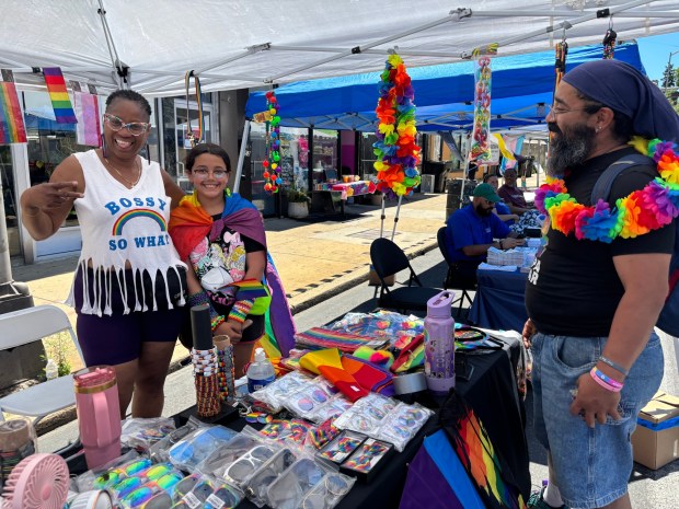 Vendor Lorraine "DJ Sweet Butterfly," left, joins Thalia Hernandez and her dad, Ernesto, Saturday at the Delco Pride Festival. (KATHLEEN E. CAREY - DAILY TIMES)