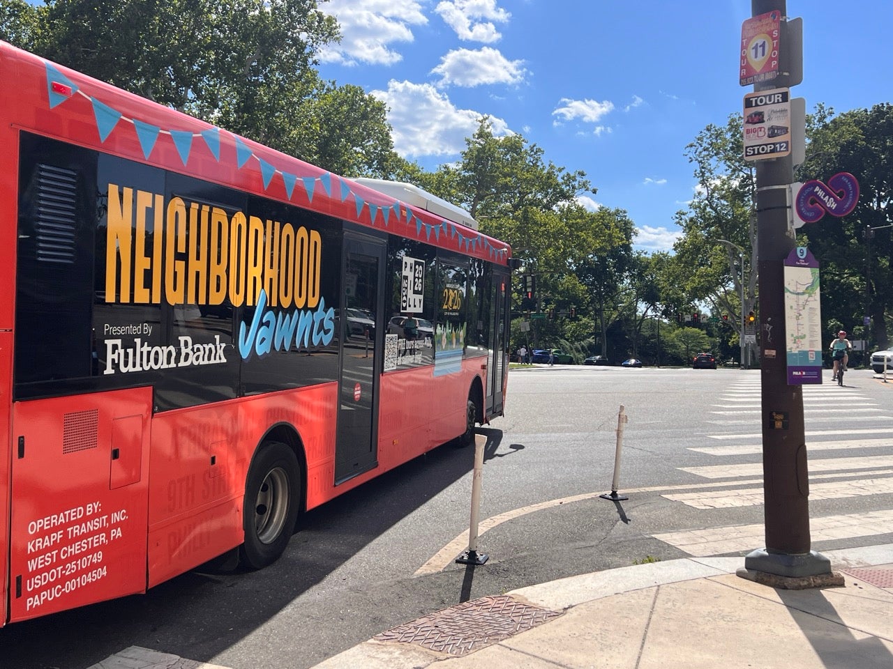 A red Philly Phlash bus turns a corner at the intersection of Fairmount and Pennsylvania Avenues in Philadelphia. Stop 9 on their route near the FIFA Fan Festival in Philadelphia.