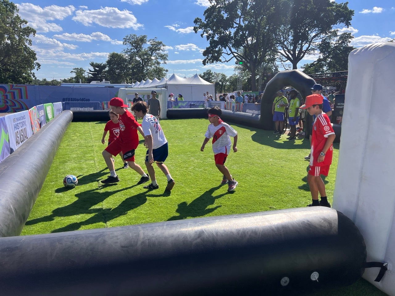 Philadelphia Union mini pitch for kids to try soccer drills at the FIFA Fan Festival in Lemon Hill. Kids playing soccer on a turf in an enclosed space.