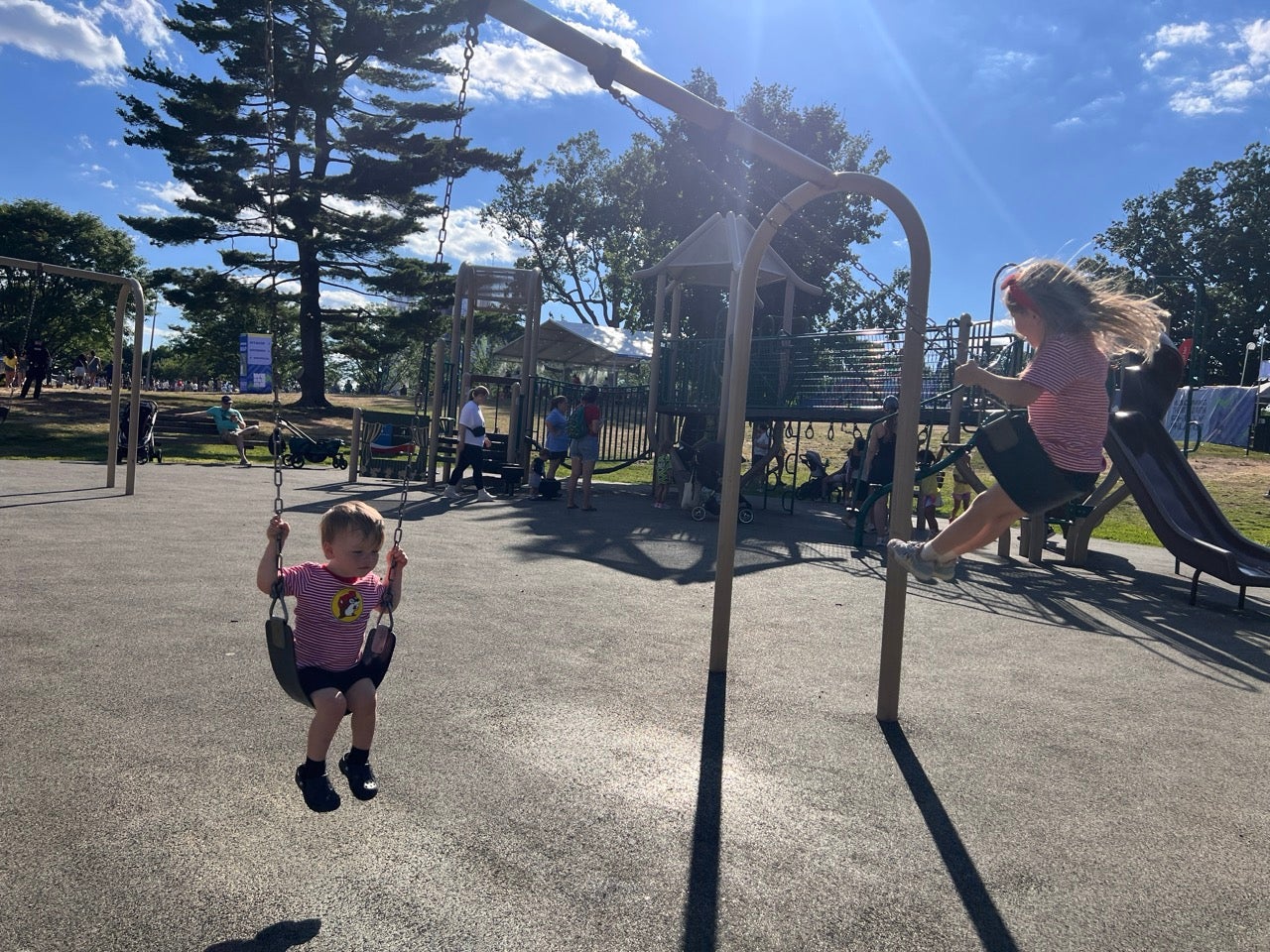 There is a playground inside the FIFA Fan Festival at Lemon Hill in Philadelphia. The photo shows Kristen's kids swinging on a sunny day on a swingset not too far from the soccer watch party going on.