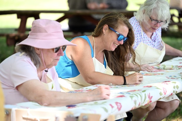 Members of the Hopewell Quilters from left Beth Shugar of Reading, Amanda Shugar of Oley and Kate Puliese of Hamburg stitch during the Americana Fest at the Berks County Heritage Center in Bern Township on Saturday, June 20, 2026. (BILL UHRICH/READING EAGLE)