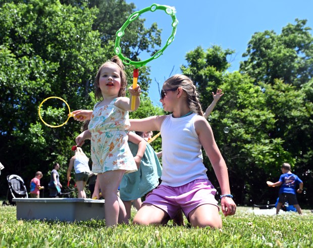 Zoe Wenrich, 2, blows bubbles with her sister Presley, 10.  (BILL UHRICH/READING EAGLE)